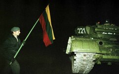 Протестующий с флагом около советского танка