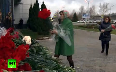 Соболезнующие несут цветы на место трагедии. Кадр телеканала Russia Today